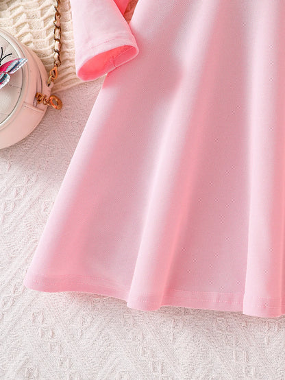 Waist seam and flared hem of the pink girls’ dress