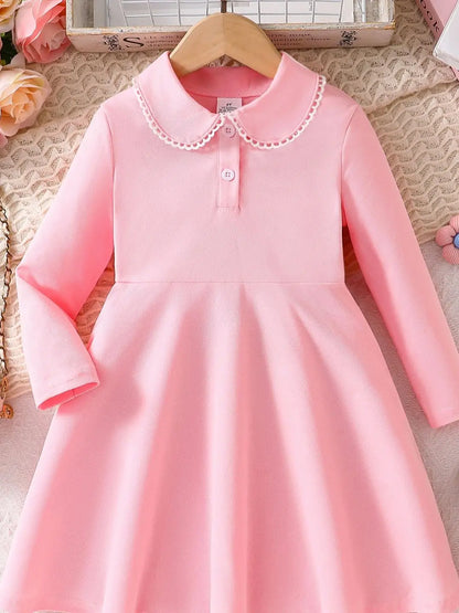 Pink long sleeve dress showing its collar, button neckline and flared shape